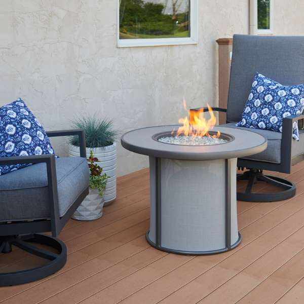 The Outdoor Greatroom Grey Stonefire Round Gas Fire Pit Table On An Outdoor Set Up