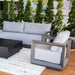 Outdoor patio furniture set with gray frame and white cushions on a wooden deck.