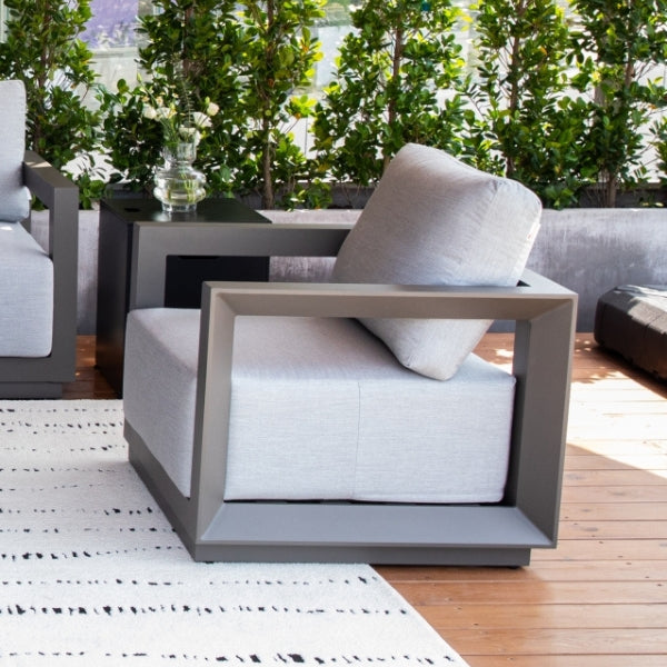 Modern outdoor furniture set with gray frames and white cushions on a wooden deck.