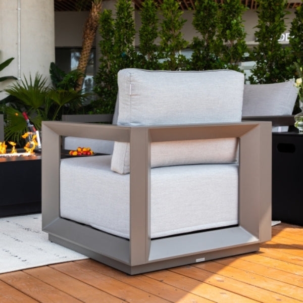 Modern outdoor chair with white cushions on a wooden deck