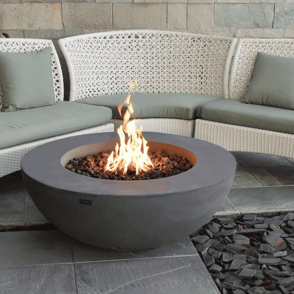 Elementi Lunar Round Concrete Fire Pit Table OFG101 Actual Photo with Flame with Couch Background  on an Outdoor Set Up