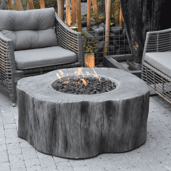 Elementi Manchester Fire Table In Classic Grey With Flame On With Accent Chair On An Outdoor Set Up