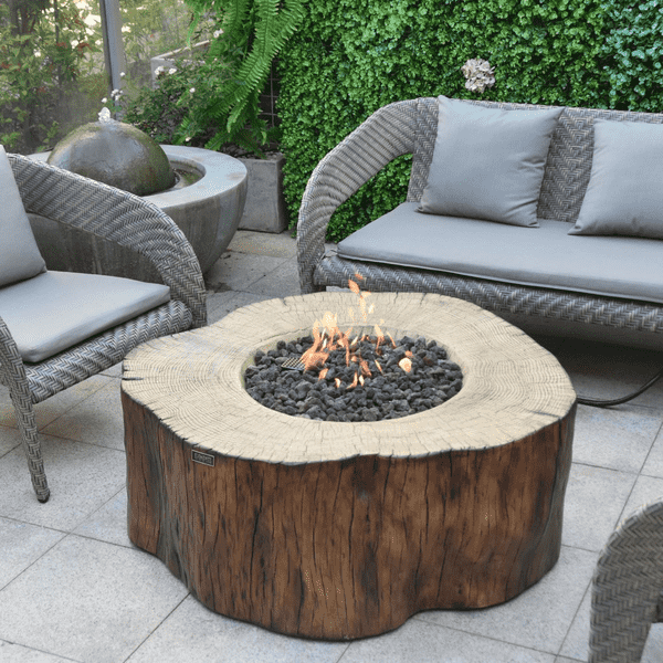 Elementi Manchester Fire Table With Flame On And Couch On A Backyard Set Up