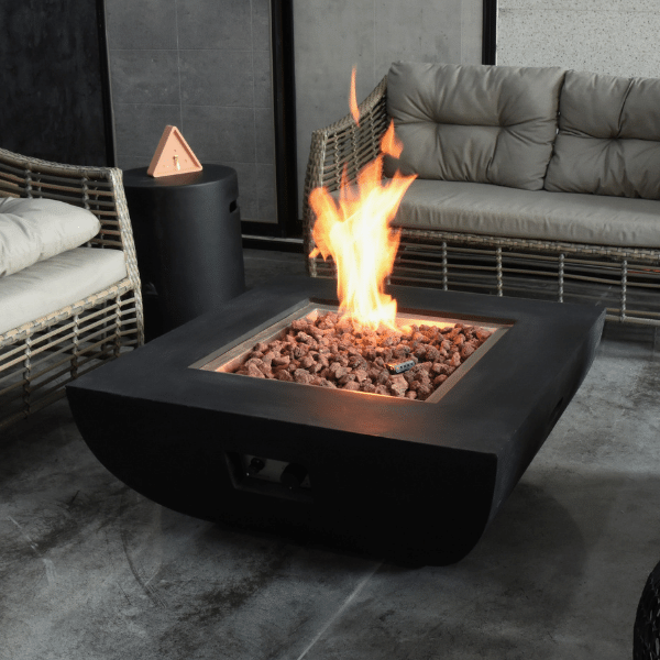 Modeno Aurora Black Square Concrete Fire Pit Table OFG114 With Flame and Propane on an Outdoor Set Up with Round Black Tank Cover, Couch and Accent Chairs