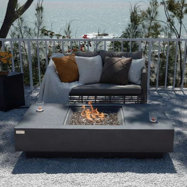 Elementi Plus Cannes Fire Table OFG416DG With Flames In Backyard Set Up With Drinks on Ledge Top View