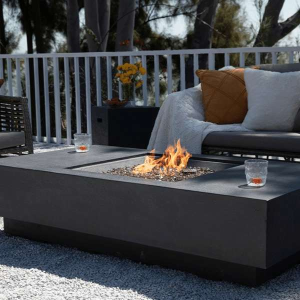 Elementi Plus Cannes Fire Table OFG416DG With Flames In Backyard Set Up Propane Tank Cover In Background