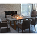 Elementi Workshop Dining Rectangular Concrete Fire Pit Table In A Dining Area With Chairs And Wine Glasses On Top
