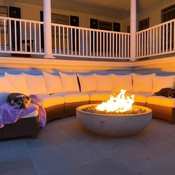     Pottery Works 48 Inch Round Concrete Fire Bowl With Flame In Natural With Couches Around On A Deck