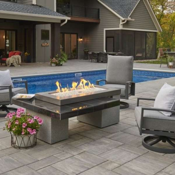 The Outdoor Greatroom Black Uptown Linear Gas Fire Pit Table With Flame On The Pool Side Area